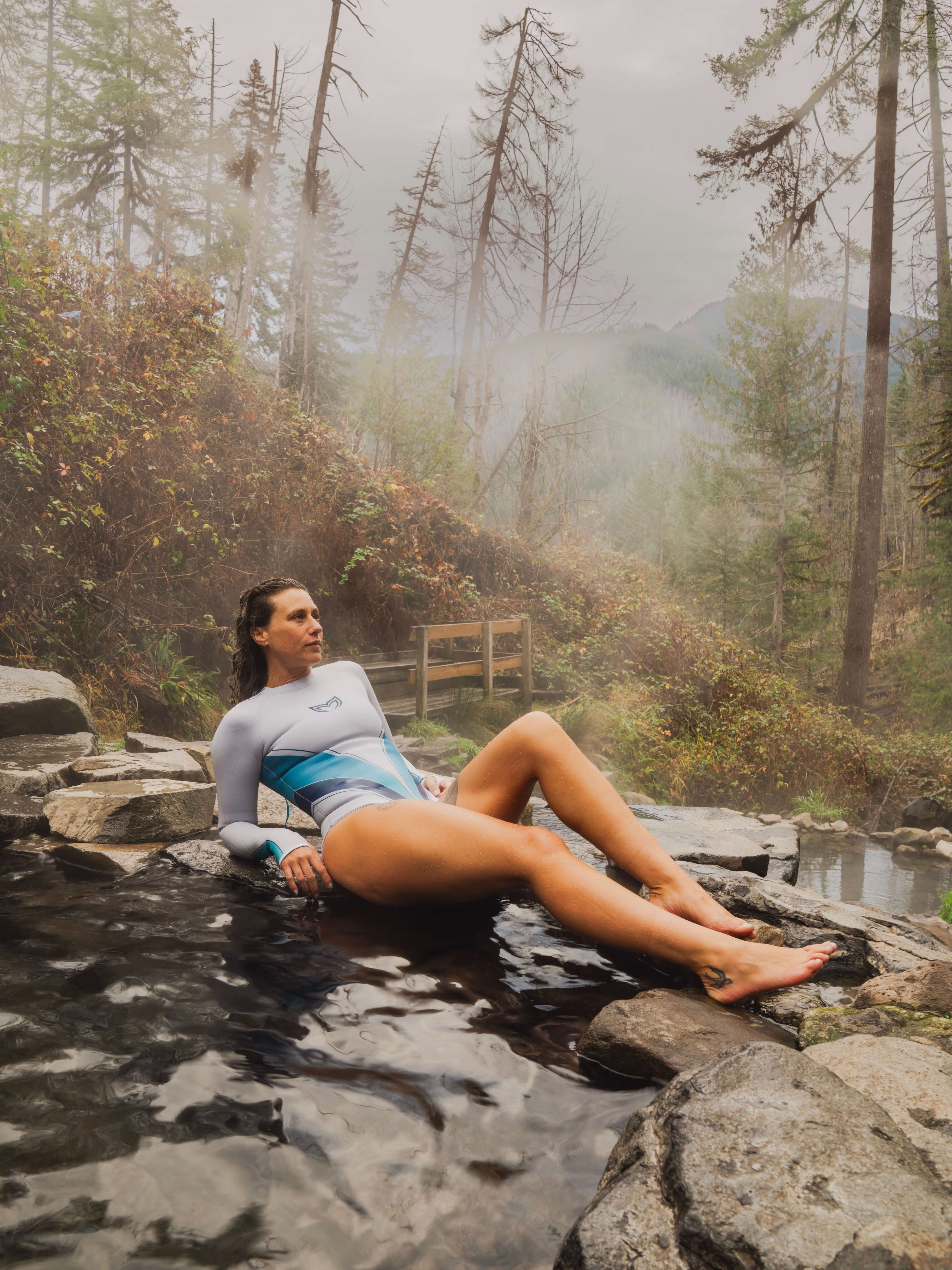 Woman in Yanita springsuit sitting by a natural hot spring