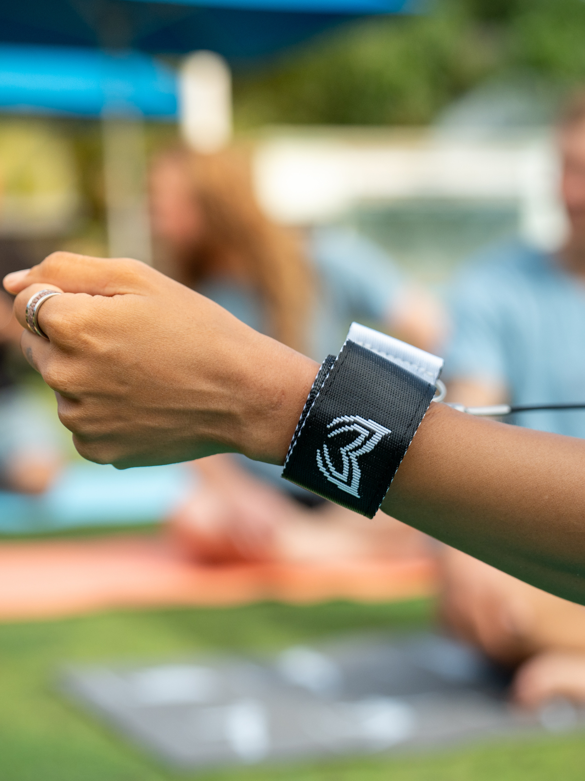 Person wearing freediving lanyard wrist cuff with Molchanovs logo outdoors