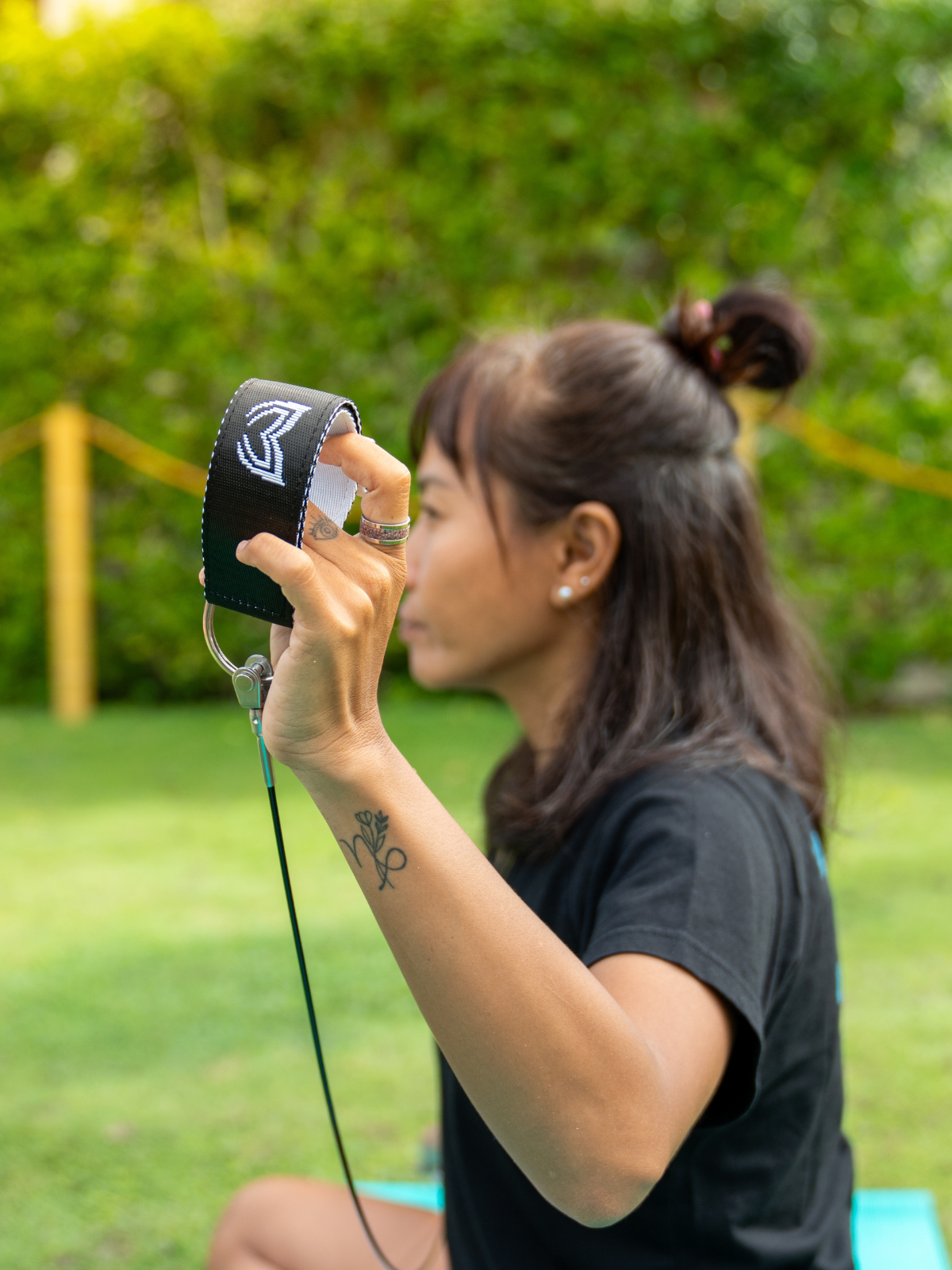 Person holding a black lanyard with molchanovs logo against a green outdoor background