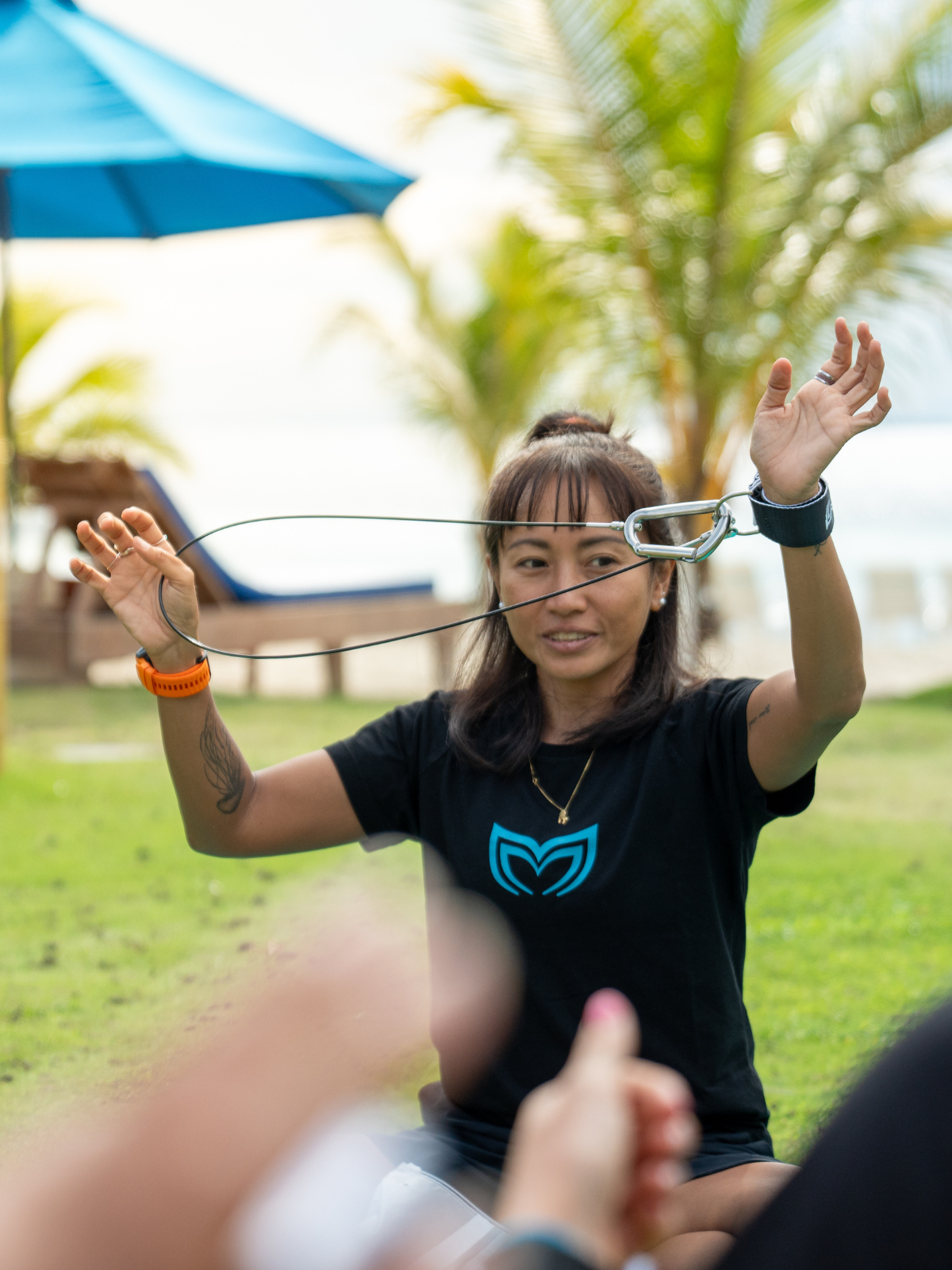 Woman demonstrating freediving lanyard to a group outdoors