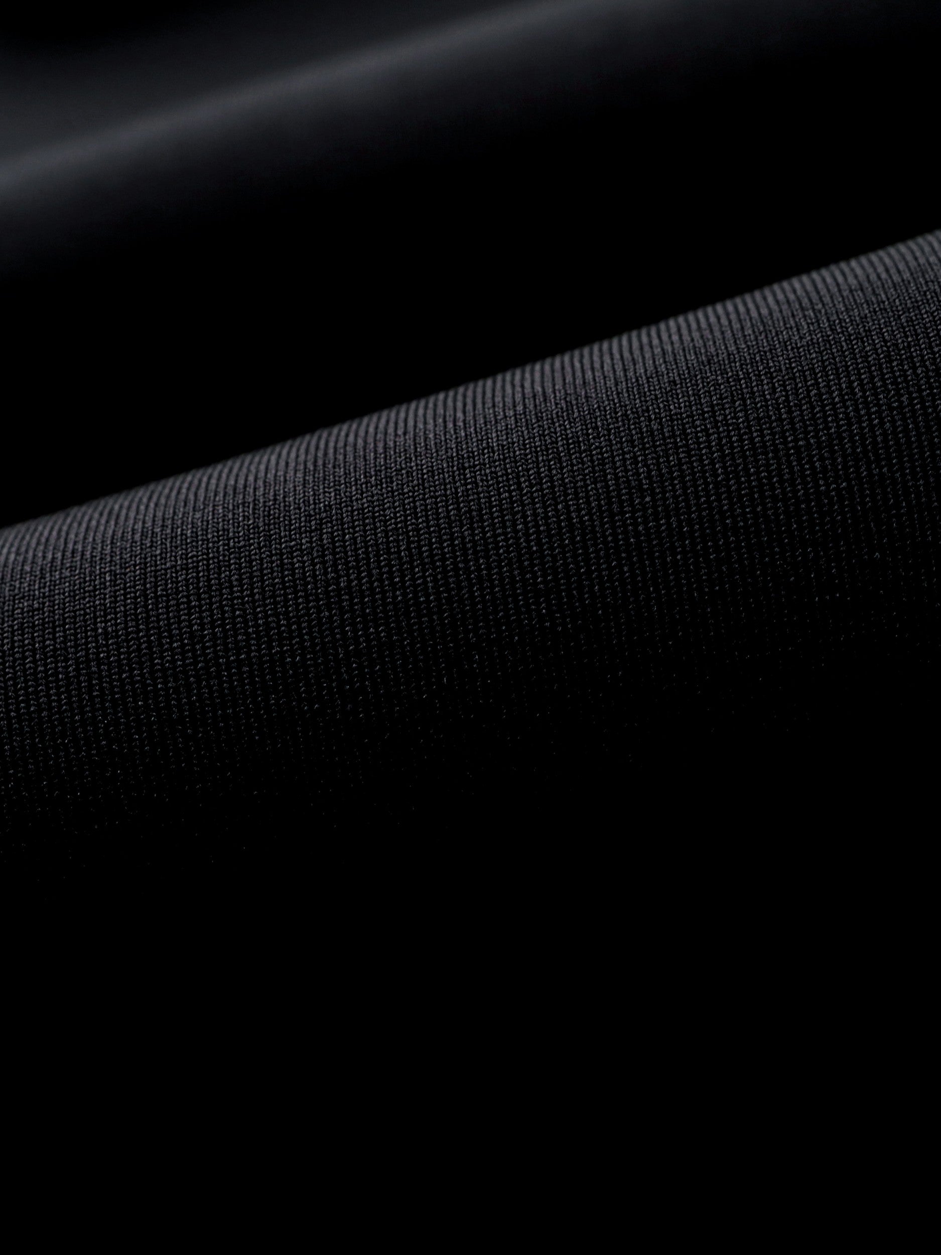 Close-up of the wetsuit's soft inner lining texture next to the smooth neoprene outer surface