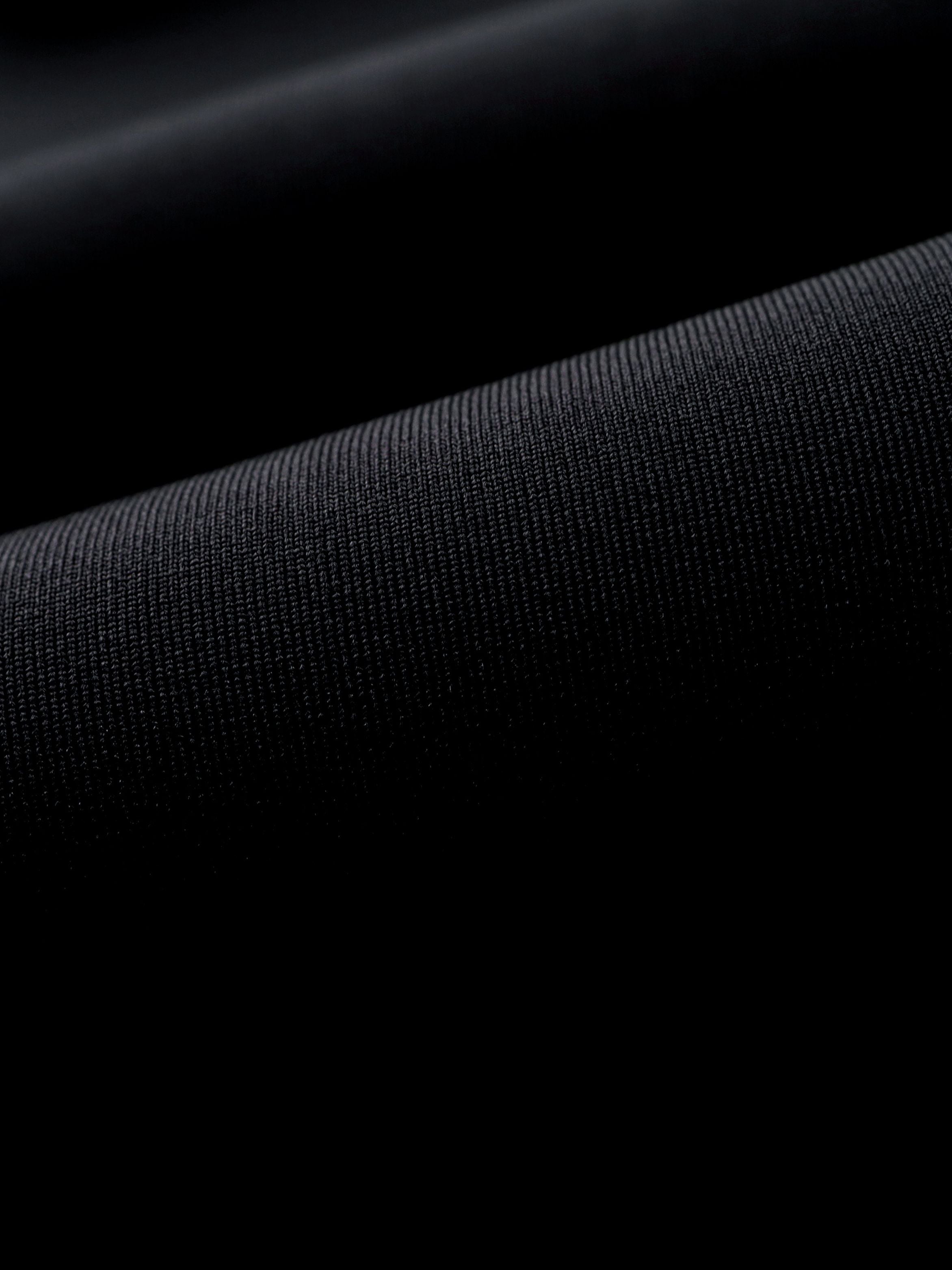 Macro texture shot contrasting the smooth outer neoprene skin and the knit inside lining of the Molchanovs SPORT wetsuit