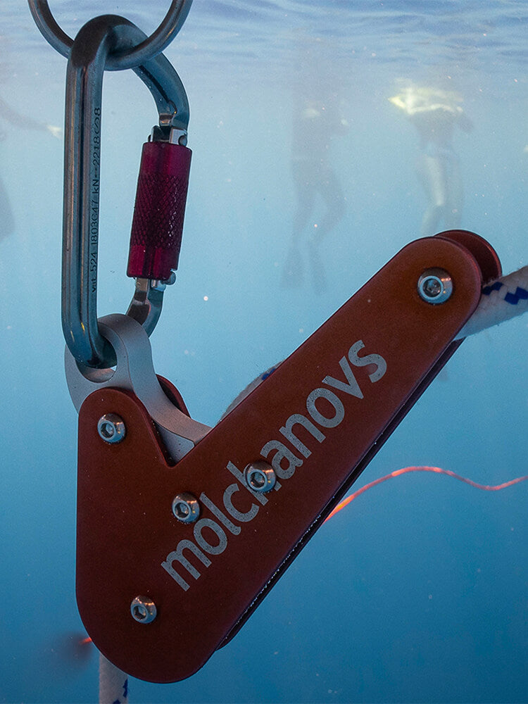 Molchanovs A6061 rope pulley clipped to a carabiner and threaded onto a dive line underwater
