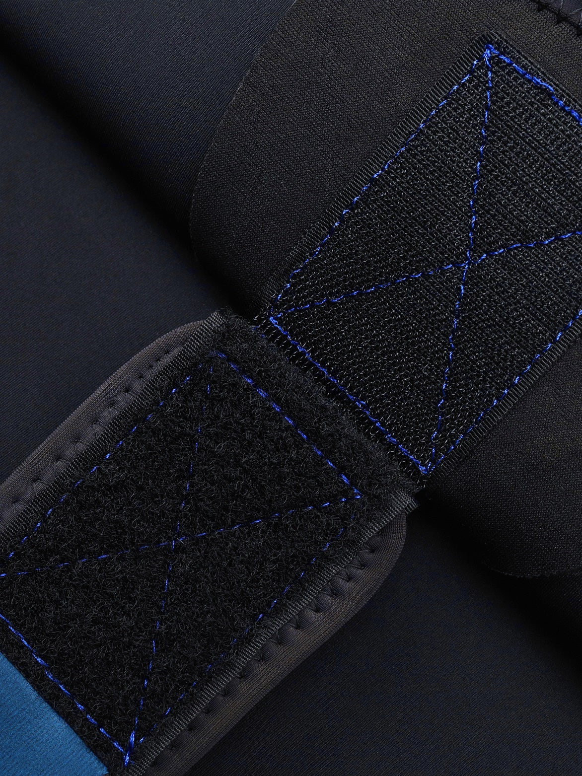 Close-up of the Molchanovs SPORT wetsuit jacket-to-pants velcro connection system with blue stitching detail