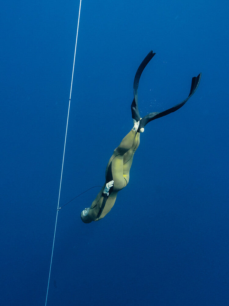 Freediver descending along a line in open water wearing Molchanovs PRO Hyper fiberglass bifins