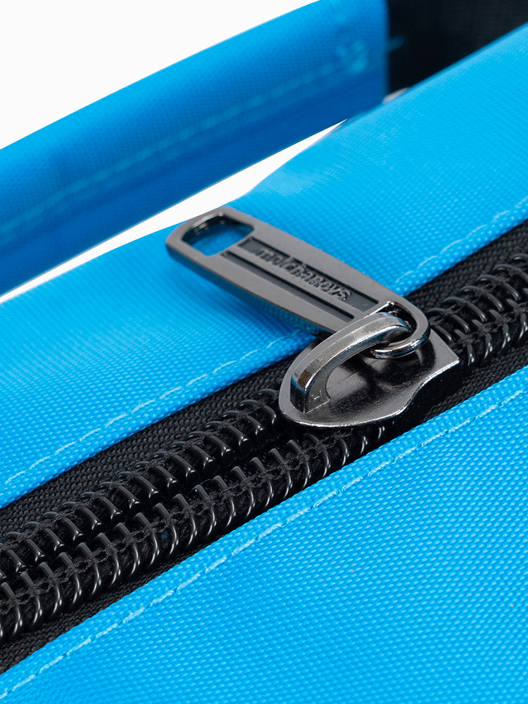 Branded Molchanovs zip pull detail on the blue Bifins Bag 3, showing gunmetal zipper and blue fabric