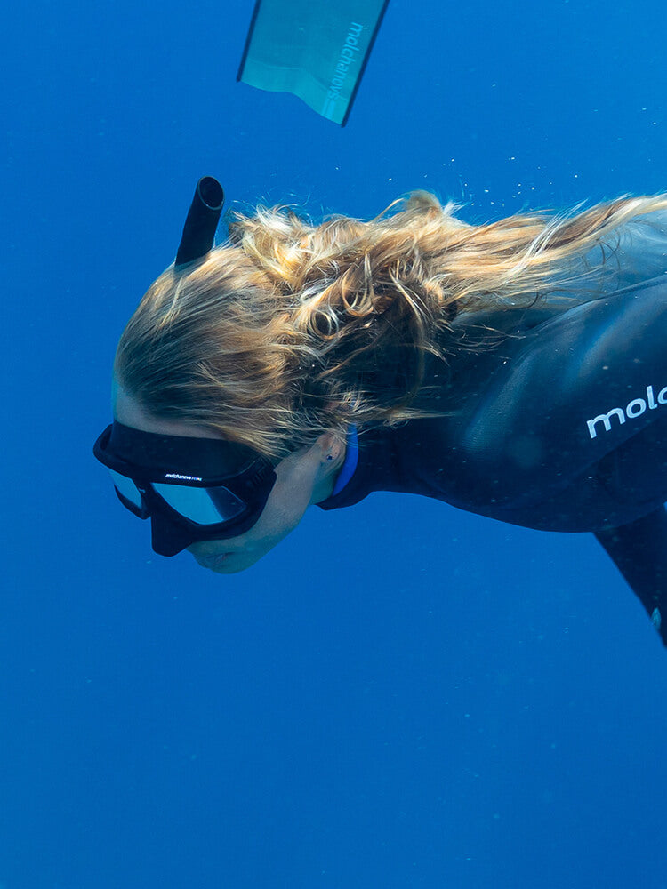 Freediver wearing the Molchanovs CORE freediving mask and snorkel underwater in open blue water