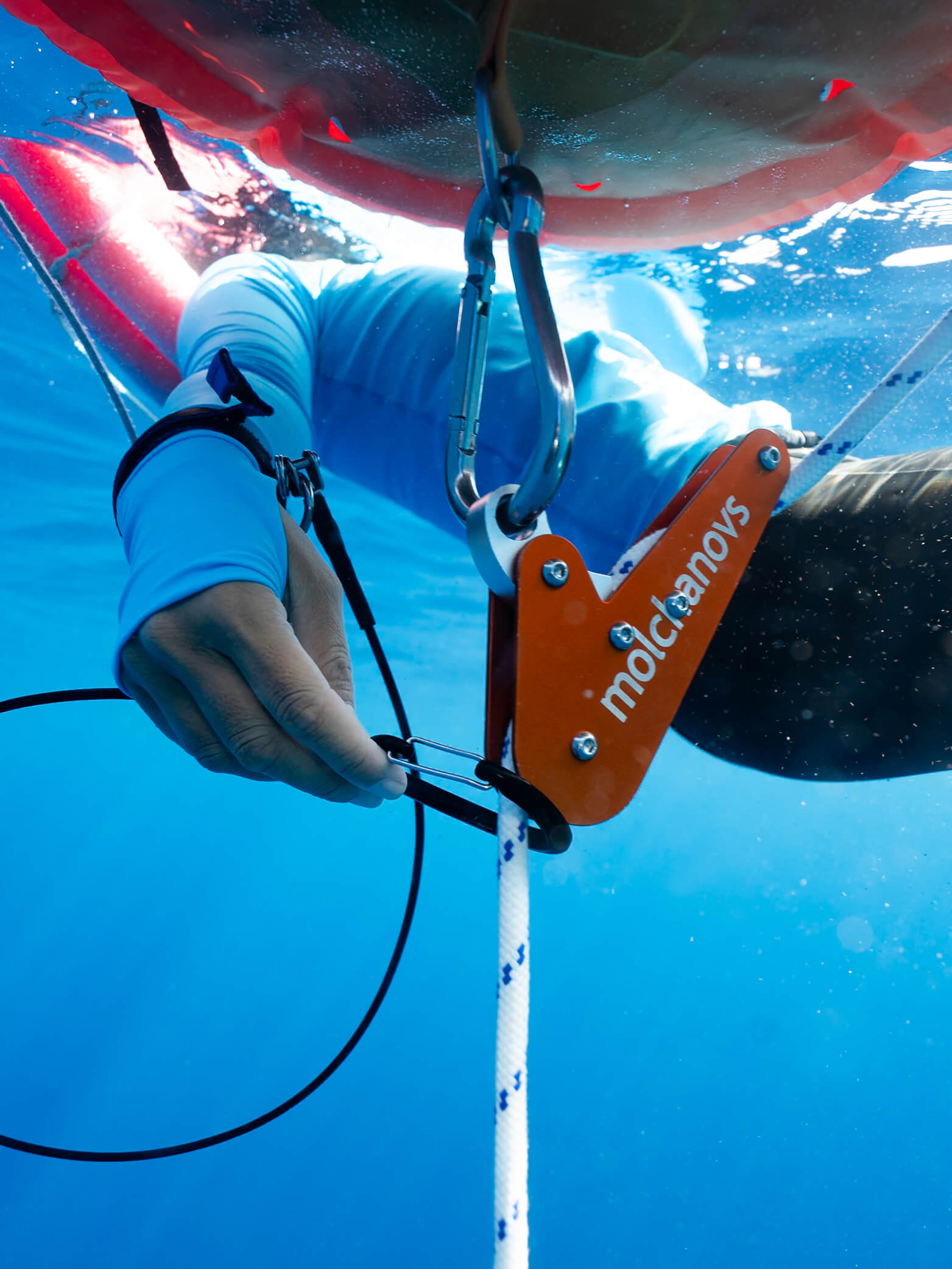 Freediver clipping the Molchanovs lanyard carabiner onto a dive buoy line at the surface