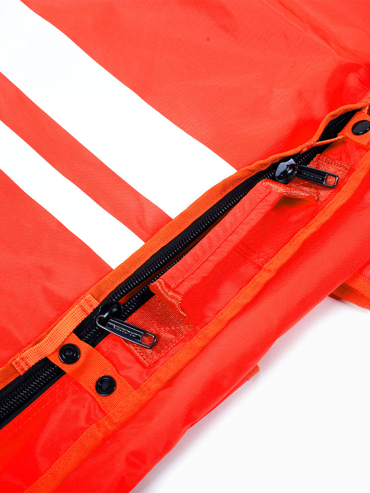 Close-up of the orange monofin bag's dual-zipper closure with snap buttons along the opening edge