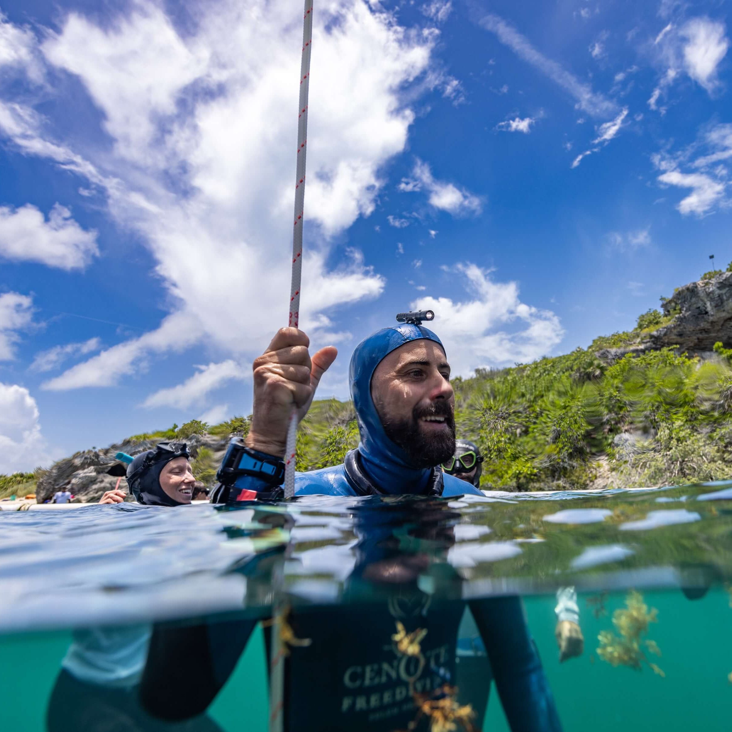 Freediving instructor signaling thumbs up at the surface during an open-water training session